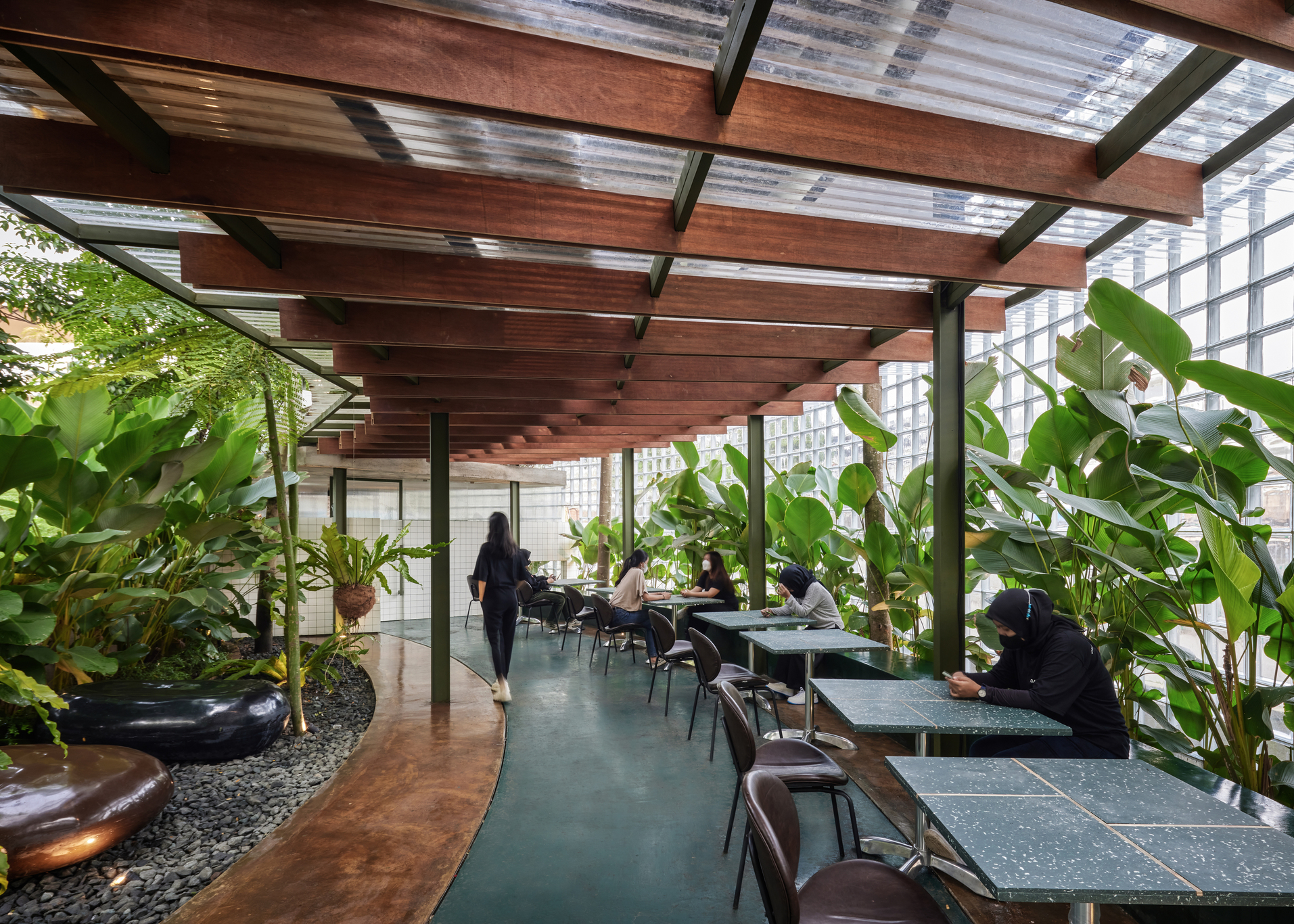 咖啡馆内则是以玻璃砖墙和大量植栽，组合出融合自然体验的用餐空间。