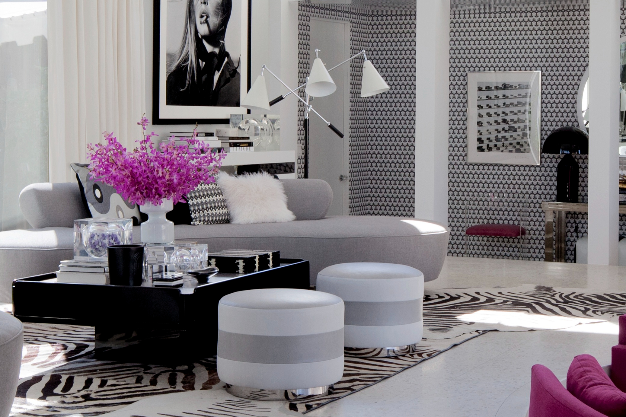 斑马皮和鲜明对比黑白挂画及几何图案壁纸，搭配灰色沙发、亮丽色彩家具家饰，让空间宛如一件普普艺术作品。