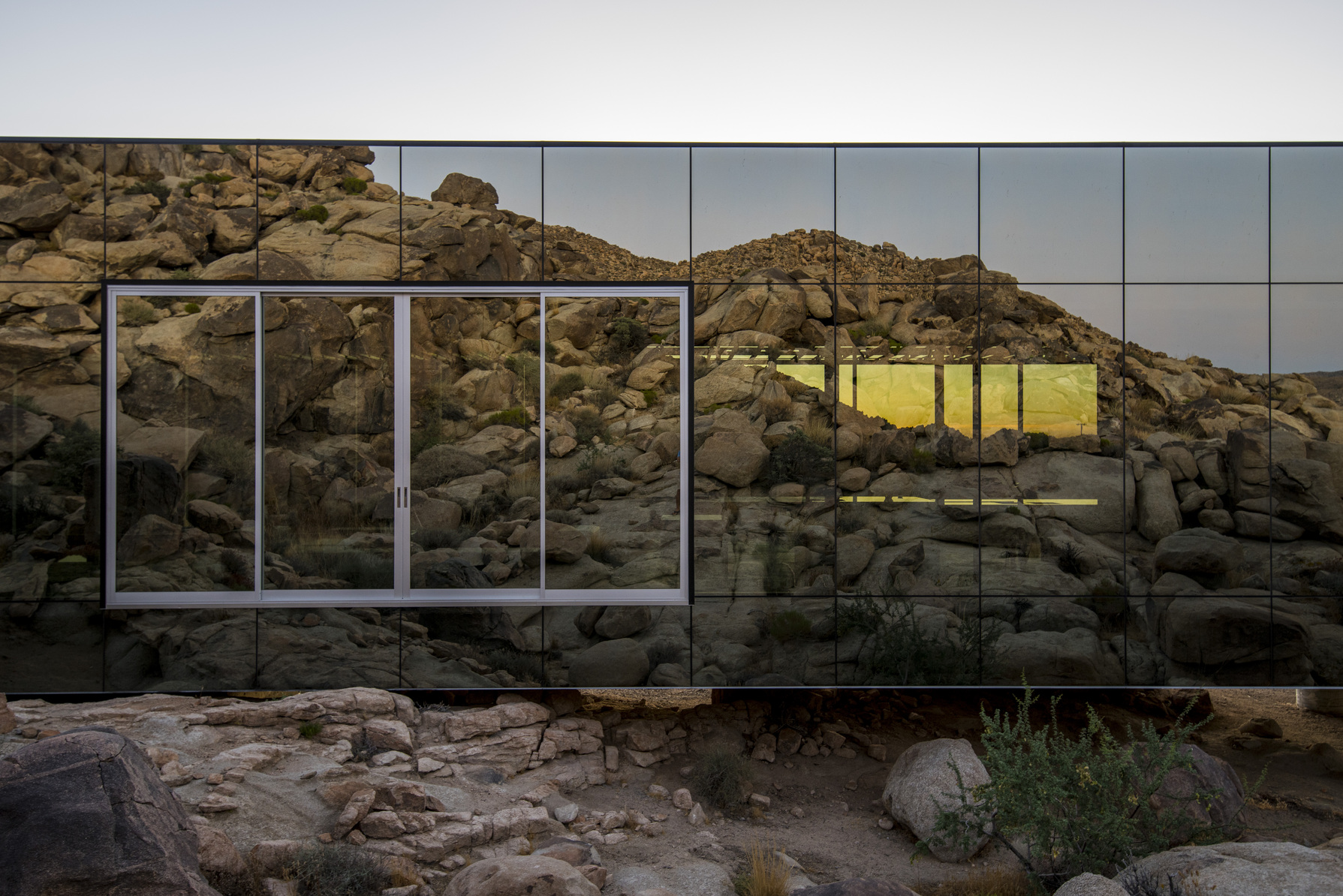 以镜面外墙映照周遭景观的 Invisible House，就如同隐形般消失在漠地中。