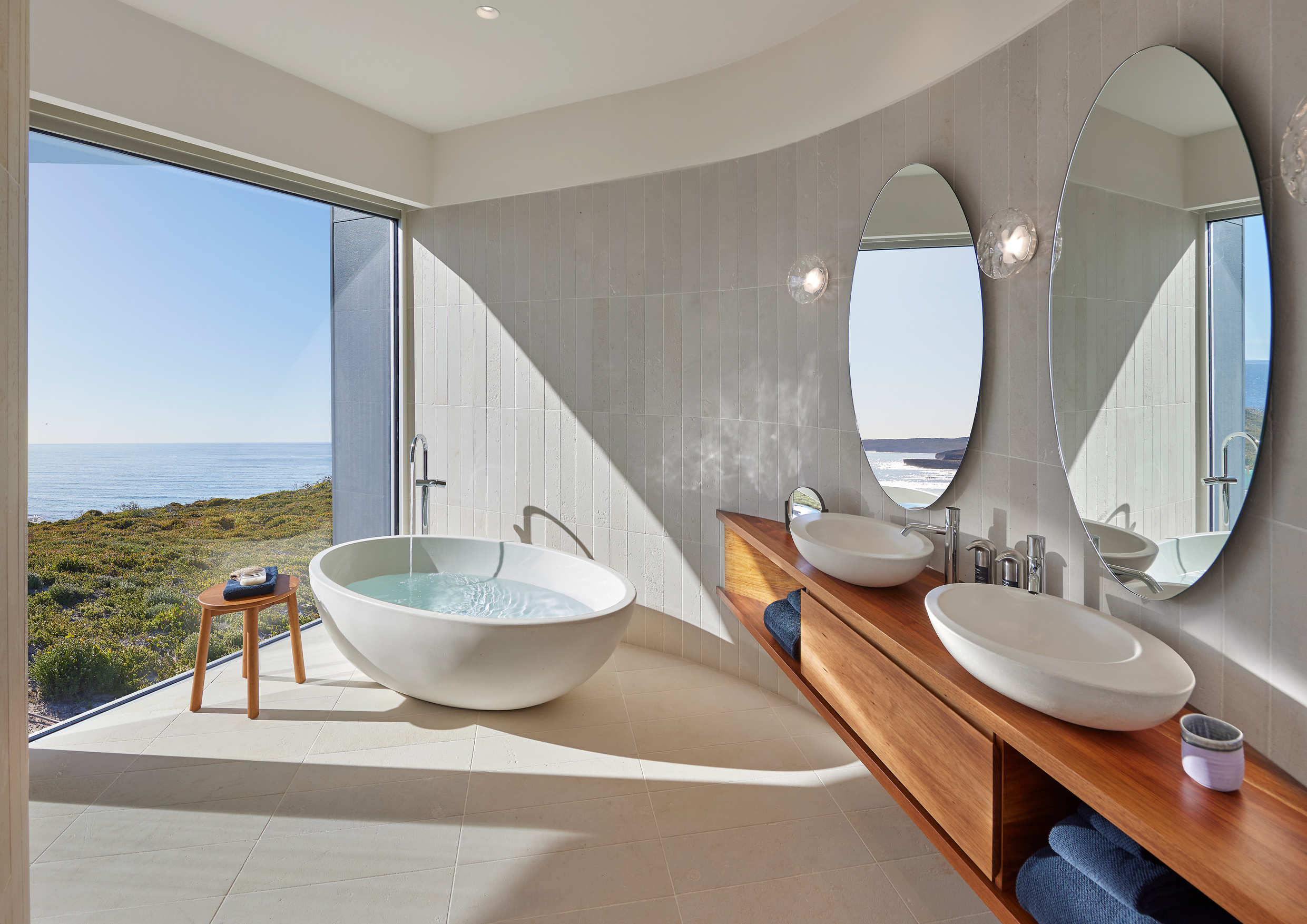 拥有一大面玻璃窗墙的套房卫浴，能一边泡澡一边欣赏海天景致。