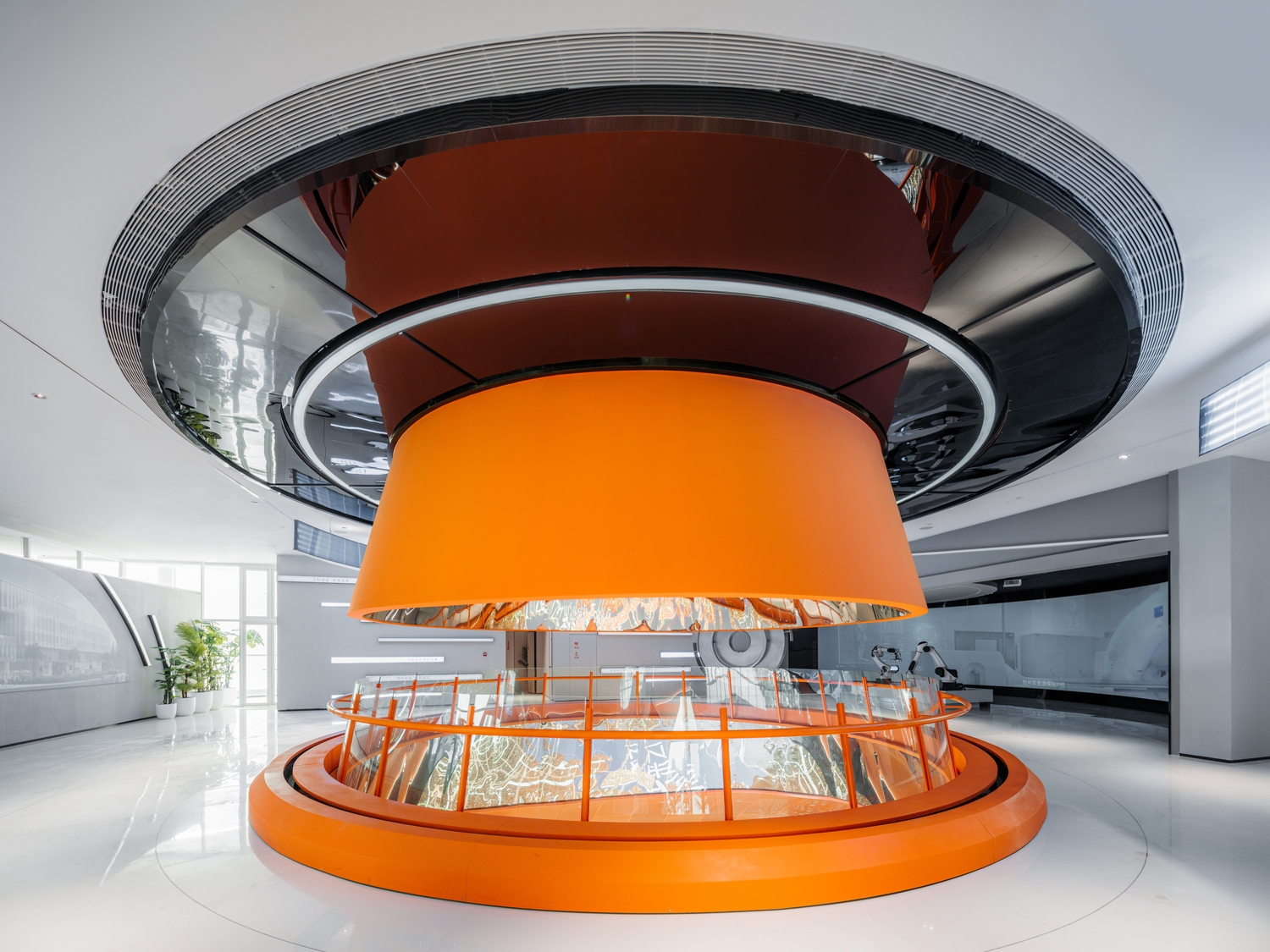 展览馆内特别以一座橘红色的圆形天井打破上下楼层的分界。
