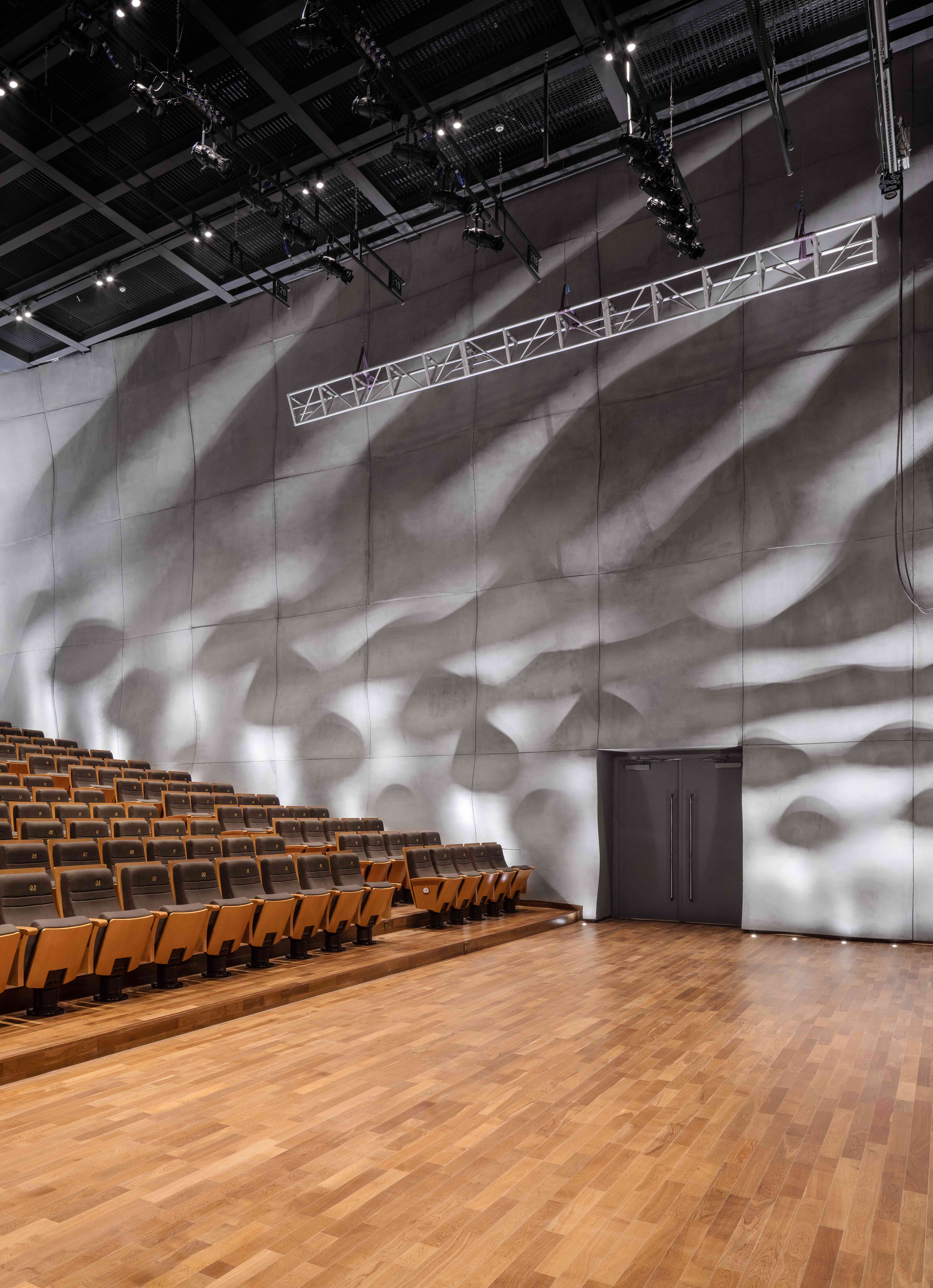 小剧场的不规则墙面在灯光的投射下，呈现出水纹般的投影。