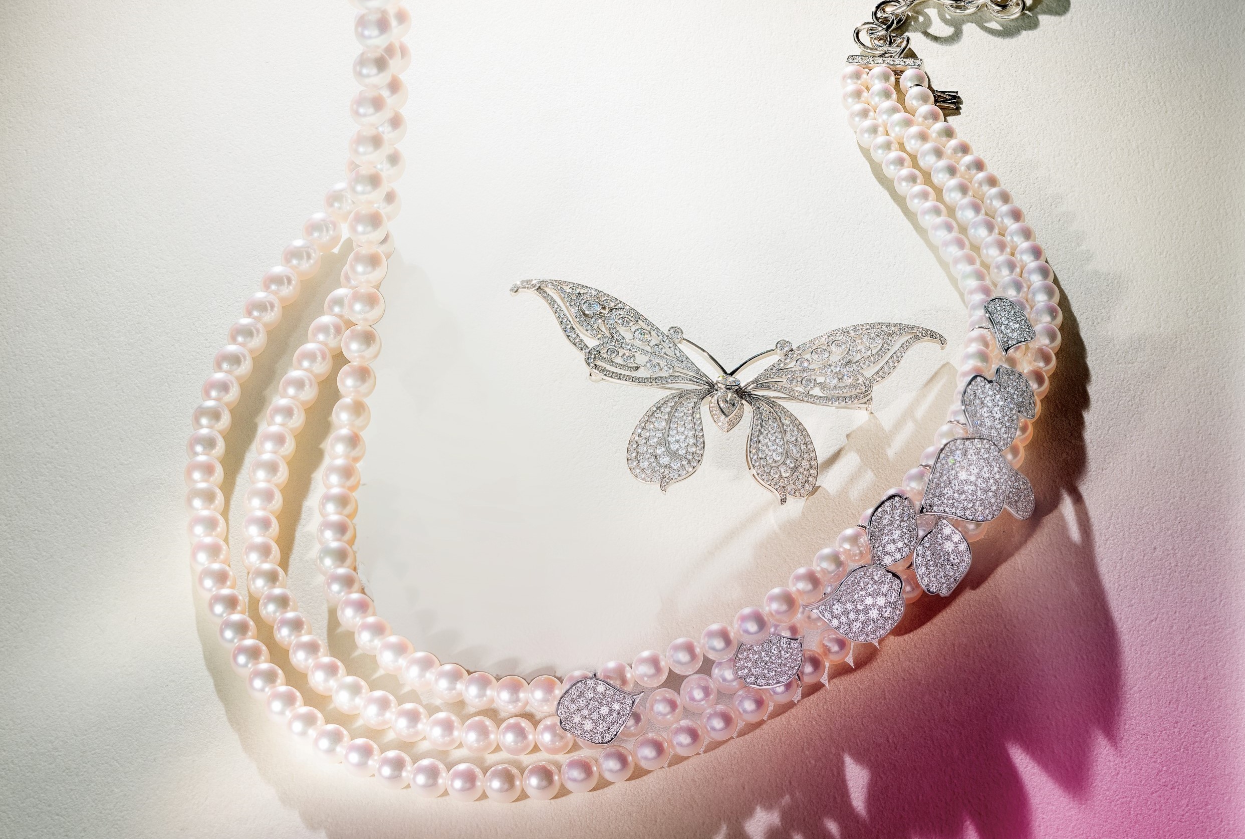 由左至右：Les Pétales Place Vendôme 系列钻石珍珠串链，Mikimoto。Tiffany 高级珠宝铂金镶钻蝴蝶胸针，Tiffany & Co.。