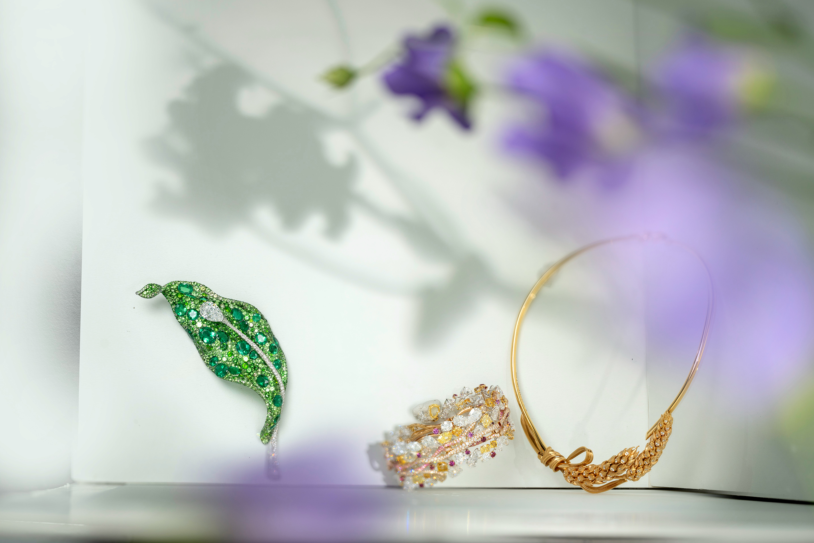 (左) CINDY CHAO The Art Jewel 二十周年系列葉片胸針，18K 白金、鈦金屬、祖母綠、鑽石、沙弗萊石、翠榴石、灰綠藍寶石。（中）CINDY CHAO The Art Jewel 四季系列樹枝手環，18K 白金、18K 黃金、18K 玫瑰金、白鑽、 黃鑽、橘黃讚、棕鑽、粉色藍寶石、玫瑰石榴石。(右) Chaumet L'Épi de Blé de Chaumet 麥穗項鍊，18K 黃金、鑽石。