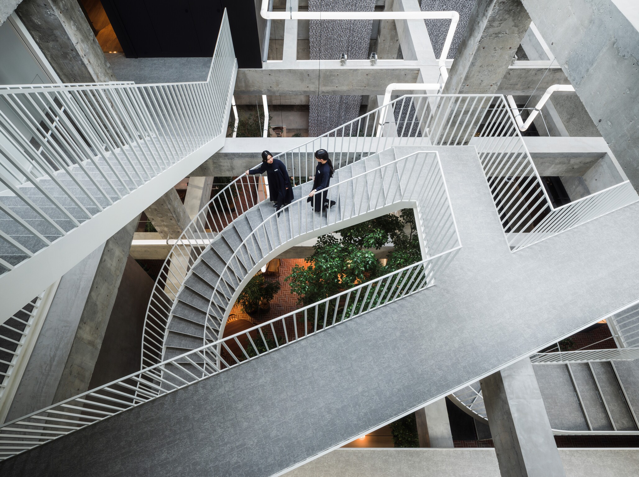 流線型階梯打破了中庭上的方正結構，創造出流動的視覺美感。
