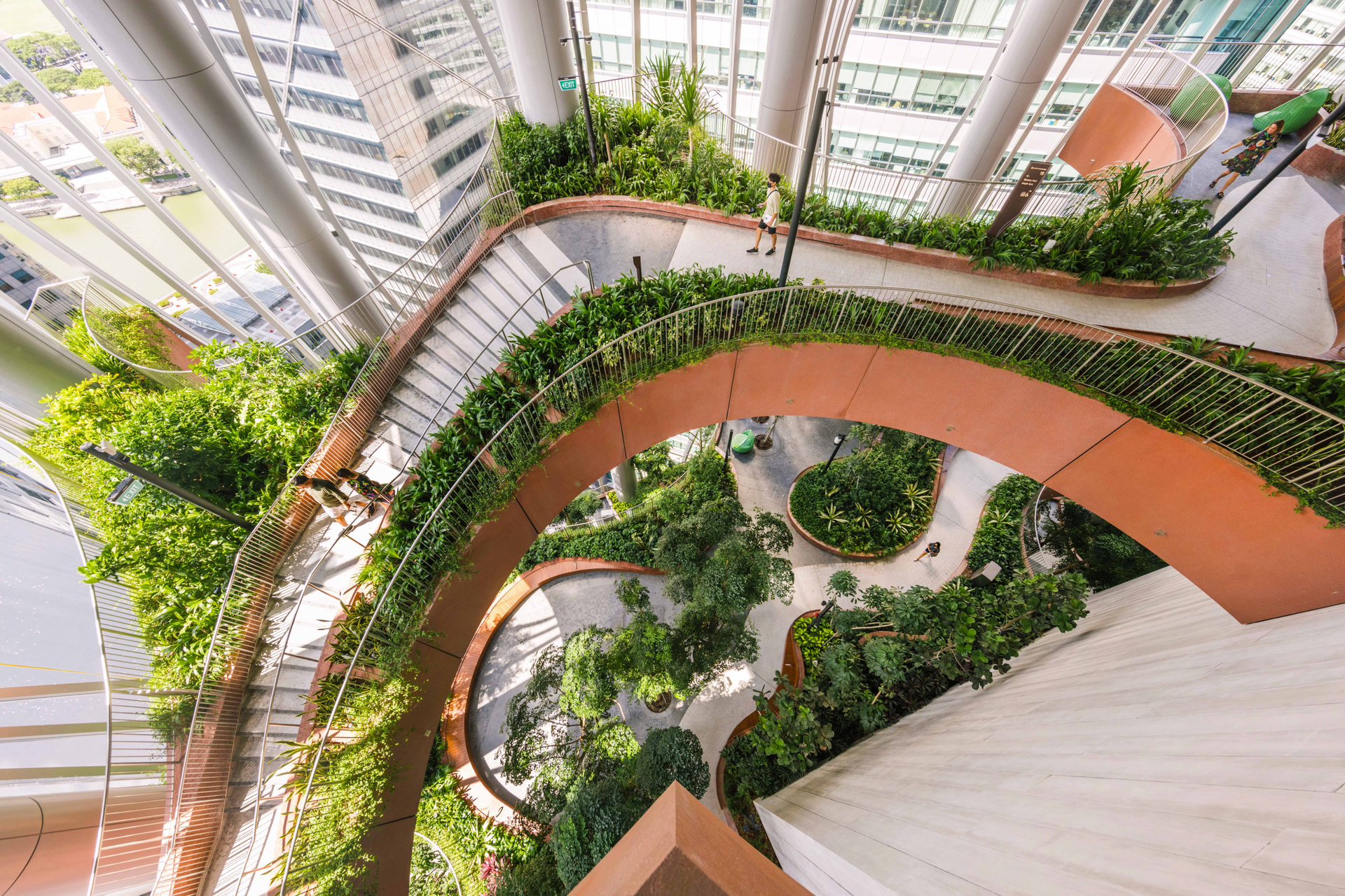 貫穿四個樓層的垂直雨林，以弧形廊道和平台設計，形成多層次的室內綠化景觀。