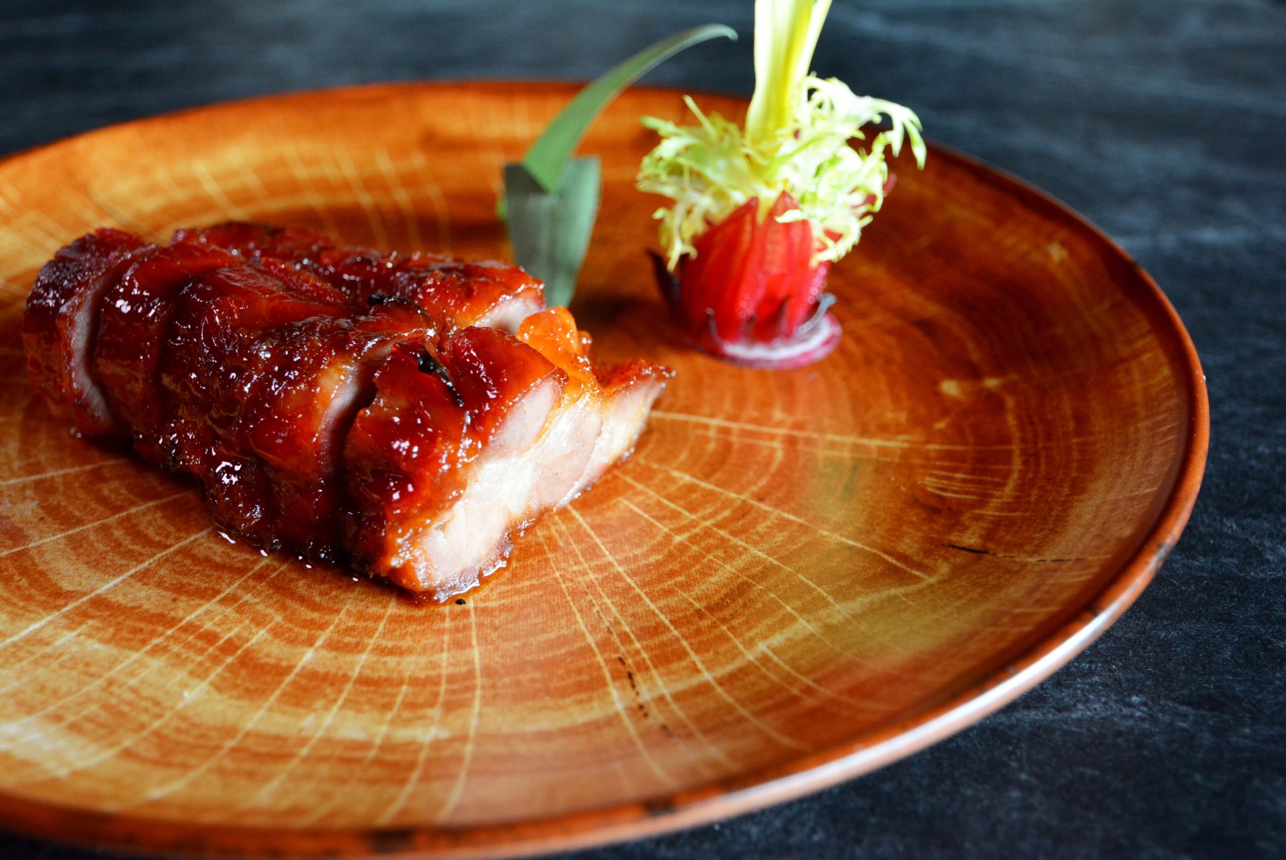 玫瑰叉烧在上桌前淋上玫瑰露酒炙烧，香气迷人，甜嫩可口。