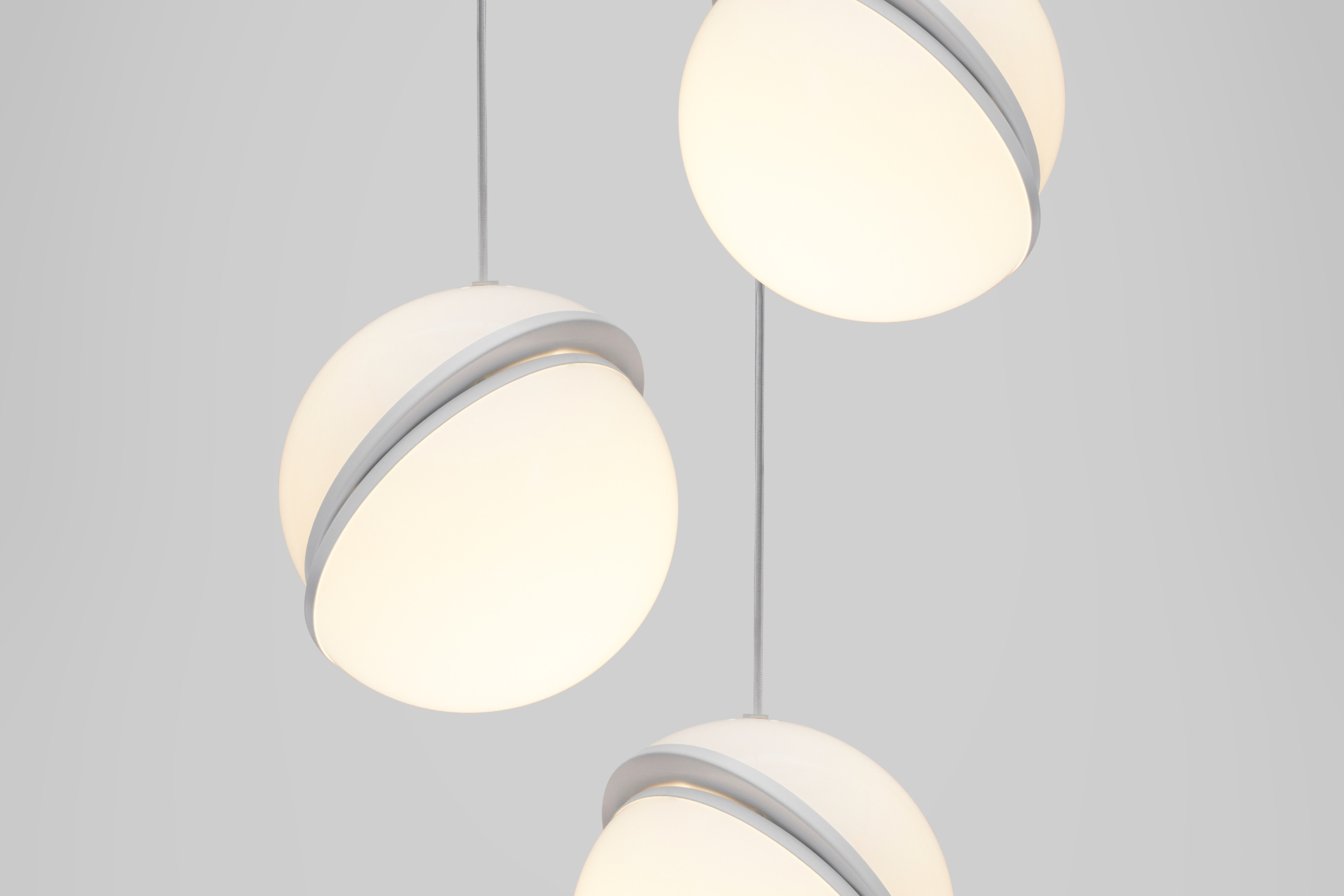 趣味的将球体切成两半，露出一个新月形的拉丝黄铜面板，Crescent 吊灯完美呈现固体和不透明体无缝地结合的创意。