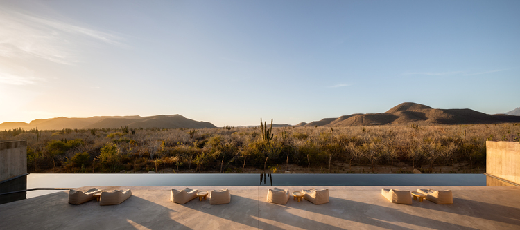 映照着夕阳和漠地风光的半月形露台与无边际泳池。