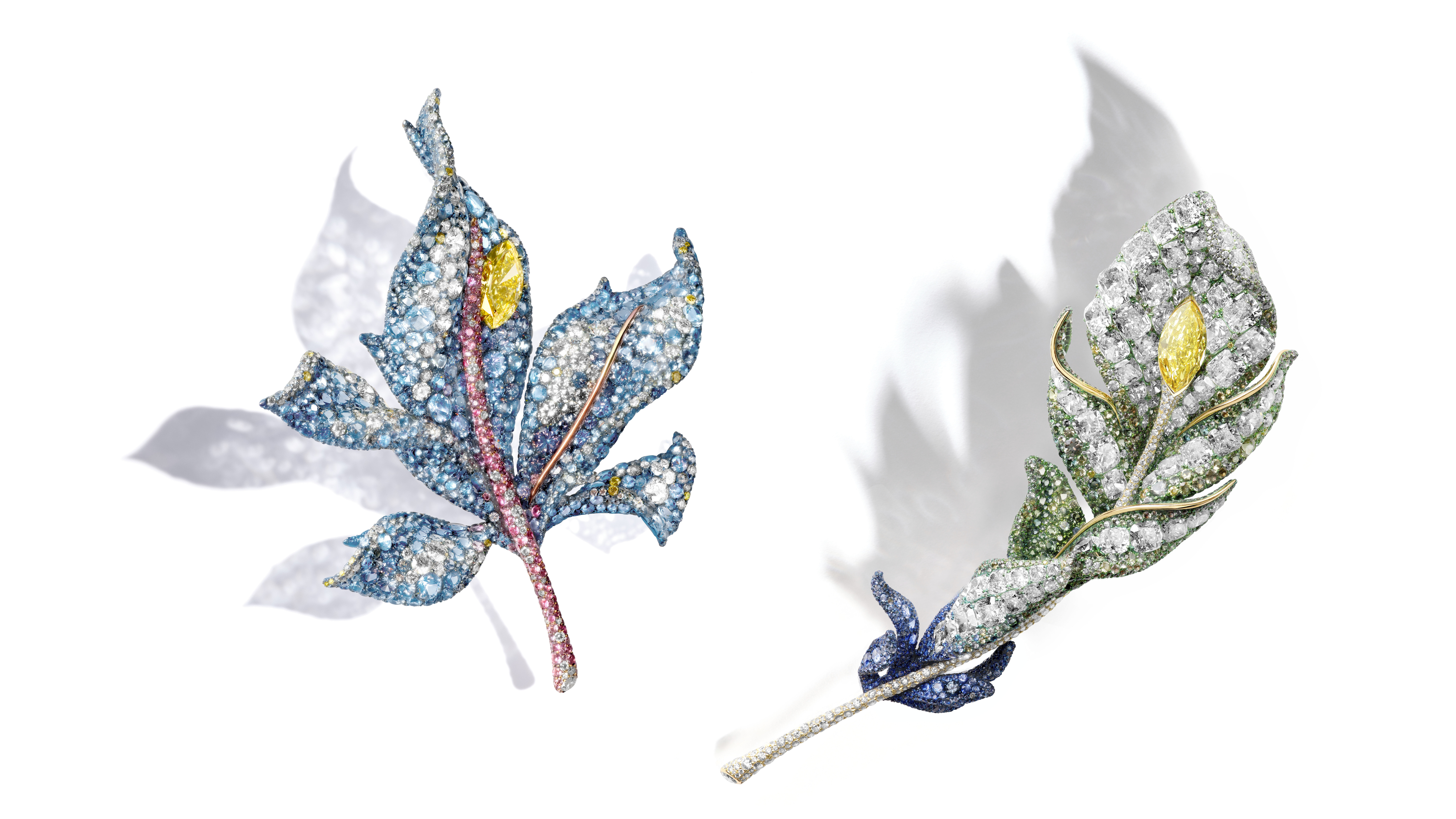 （由左至右）四季系列楓葉胸針，3 克拉馬眼型濃彩黃鑽、白鑽、黃鑽、藍寶石、海藍寶石、粉色藍寶石、鈦金屬、18K 黃金。 二十周年系列羽毛胸針，黃鑽、白鑽、偏灰綠色藍寶石、藍寶石、 偏灰藍寶石、沙弗萊石、鈦金屬。