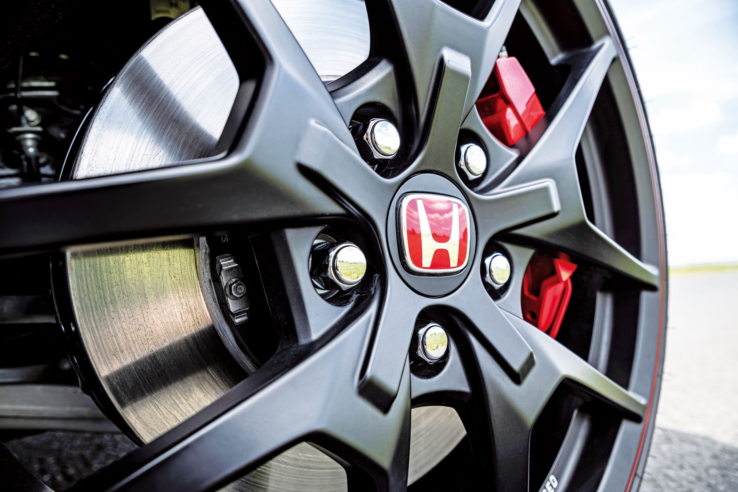 Civic Type R 充满视觉张力，满到几乎要爆开的刹车碟盘与卡钳。