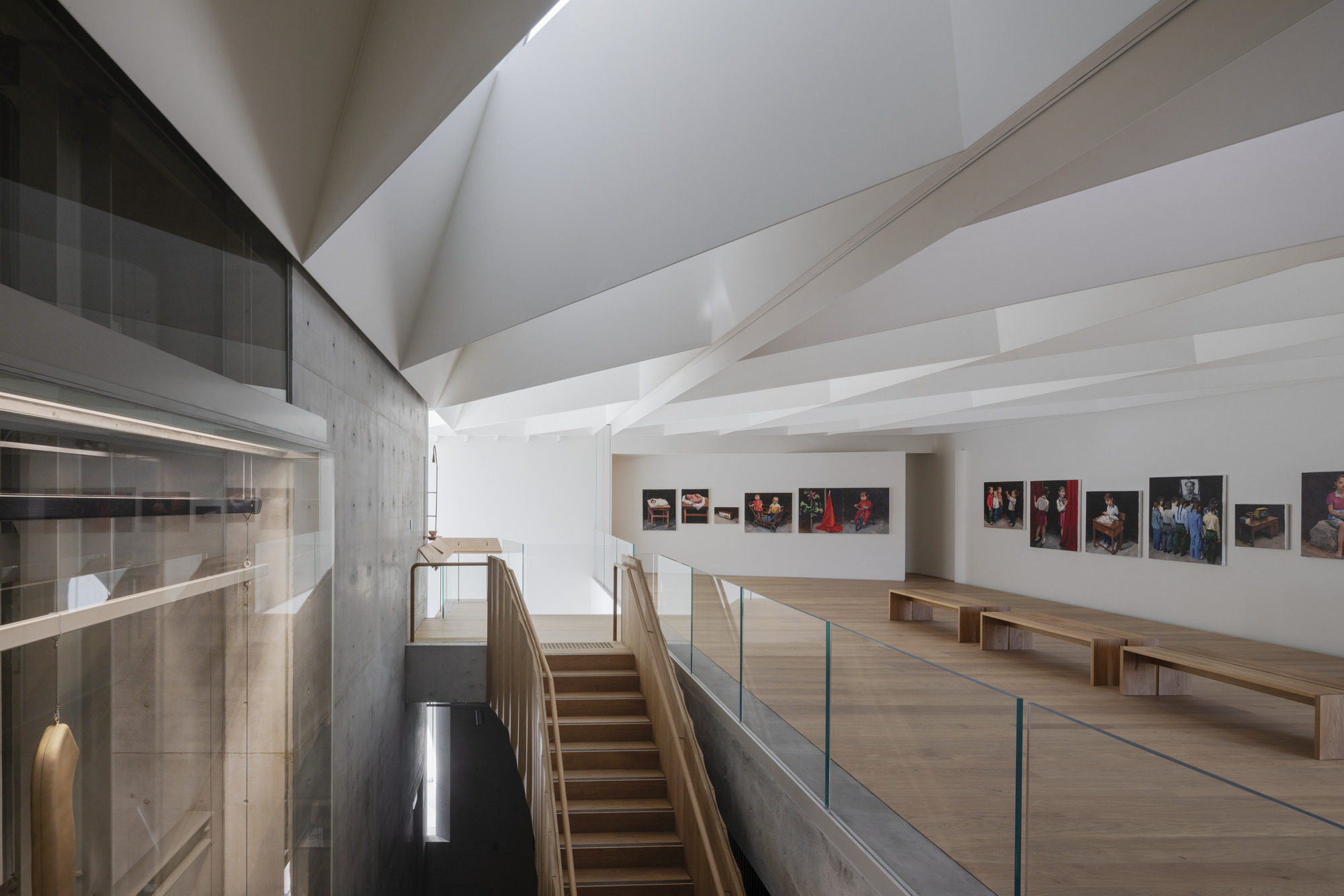 以清水模墙面、原木地板和 立体几何天花板，组合出极简又雅致的艺廊空间。 （ Photo by Trevor Mein ）