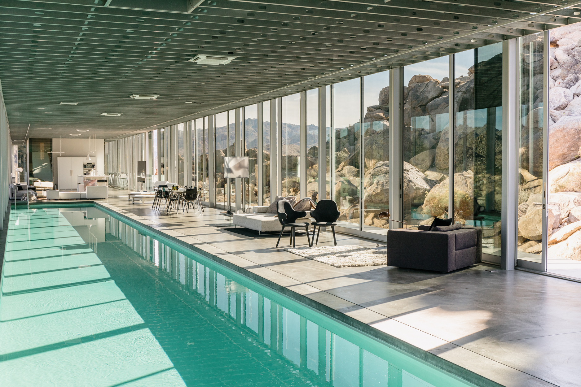 长 100 英尺的室内泳池搭配玻璃墙幕，营造出前卫又超现实的空间场景。