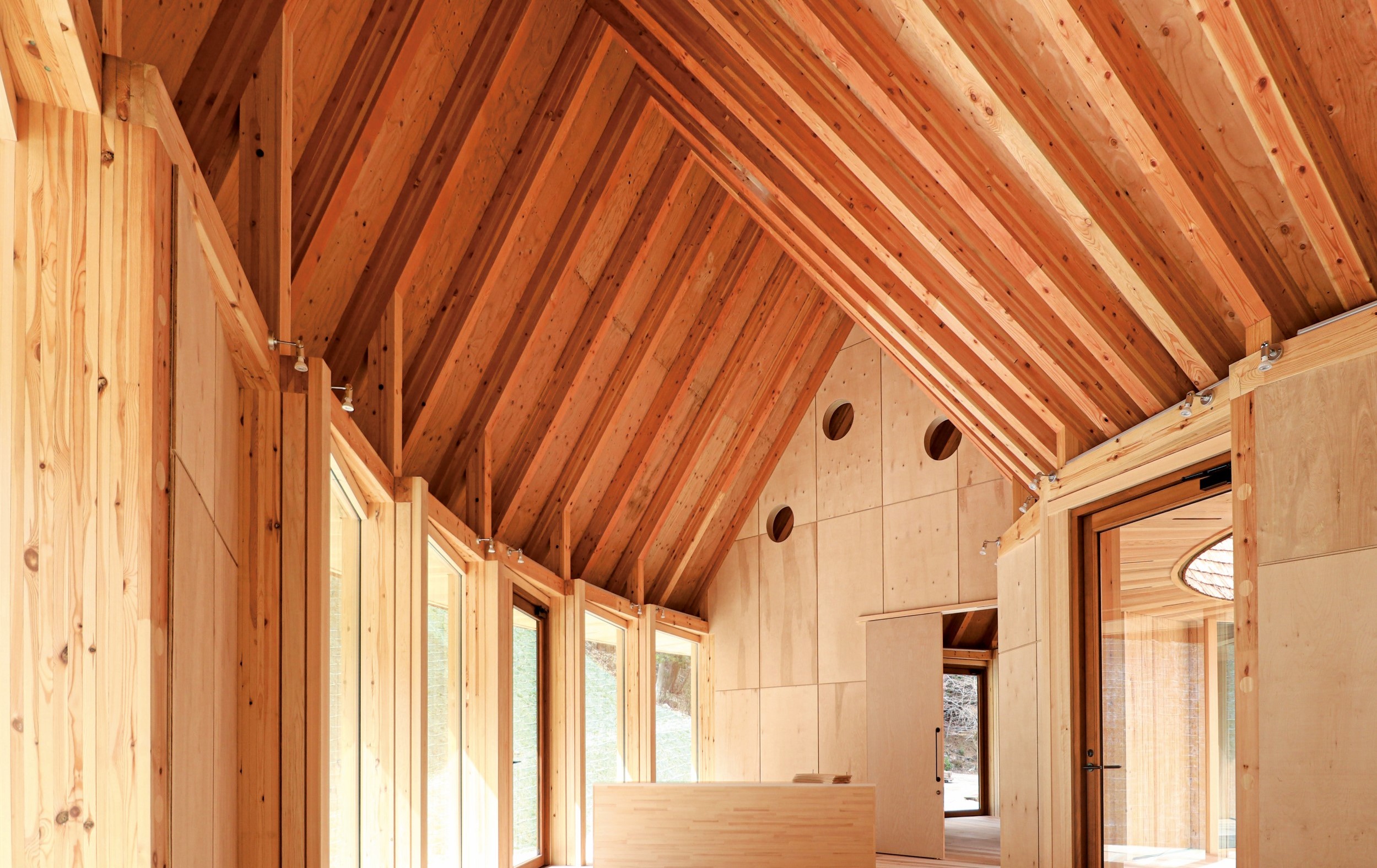 以原木建造出的永續建築，也以大量的落地窗採擷自然光照。